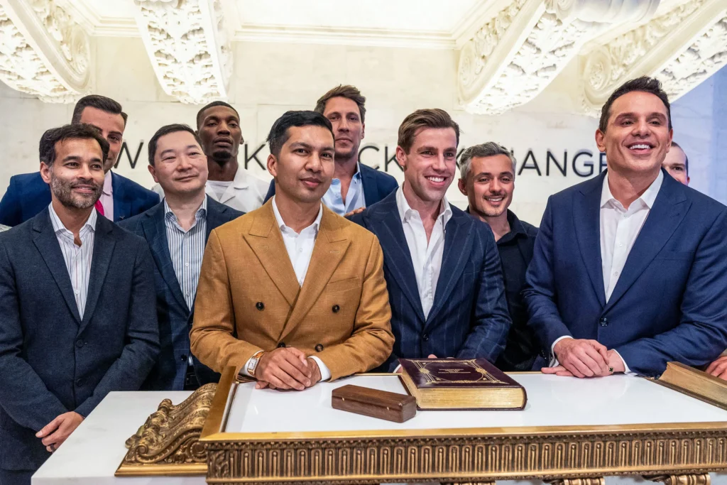 All'inizio di maggio, Enhanced ha iniziato a essere quotata alla Borsa di New York con un valore iniziale di 1,2 miliardi di dollari. Christian Angermayer è in piedi all'estrema destra con Max Martin alla sua sinistra (in prima fila) e Aron D'Souza accanto a lui. LEV RADIN/ZUMA PRESS WIRE VIA ALAMY